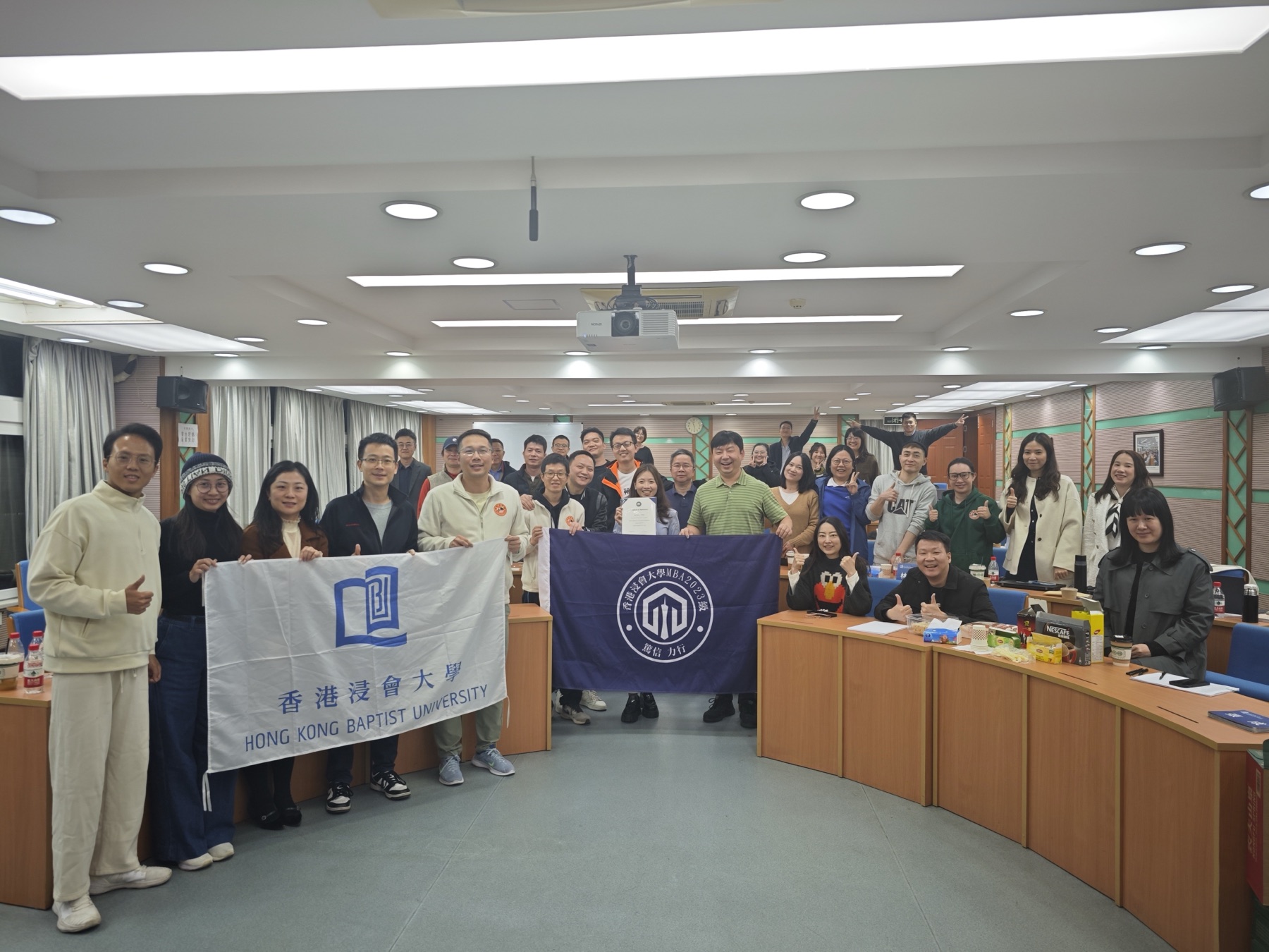 香港浸会大学课堂合影，学生举着校旗